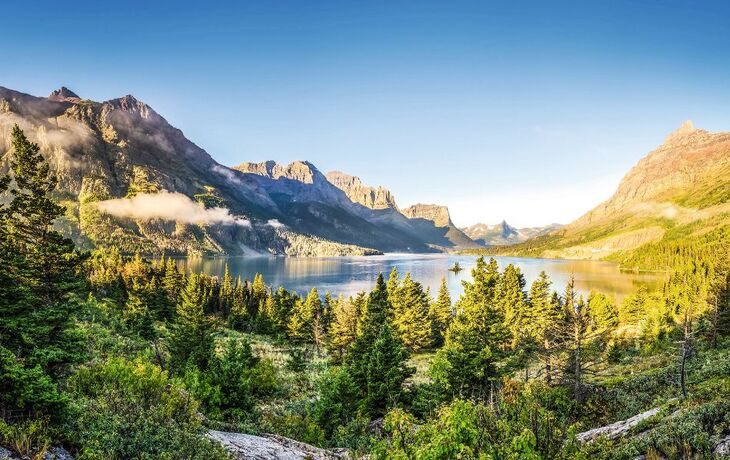 Panoramic landscape view of Glacier NP mountain range and lake